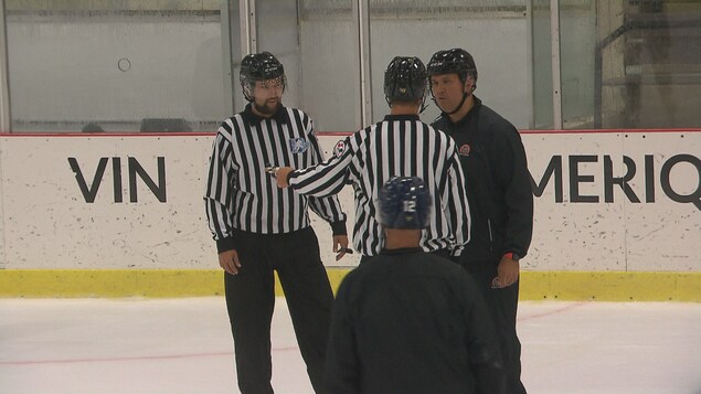 Justin St-Pierre qui parle avec deux arbitres.