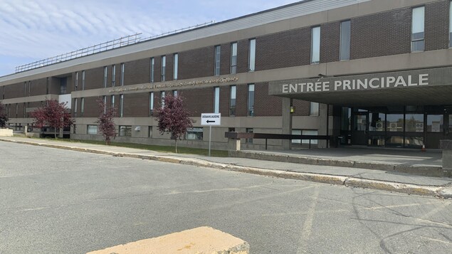Vue de l'entrée principale de l'établissement scolaire à partir du stationnement.