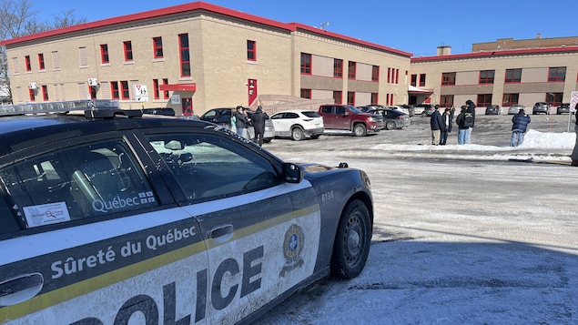 Une voiture de la SQ se trouve devant une école secondaire.