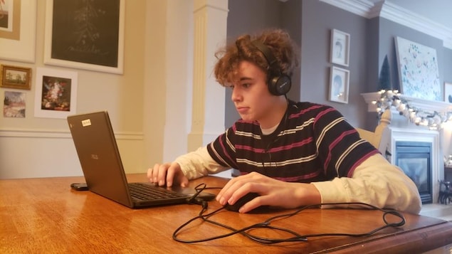 Étudiant à l'ordinateur avec des écouteurs.