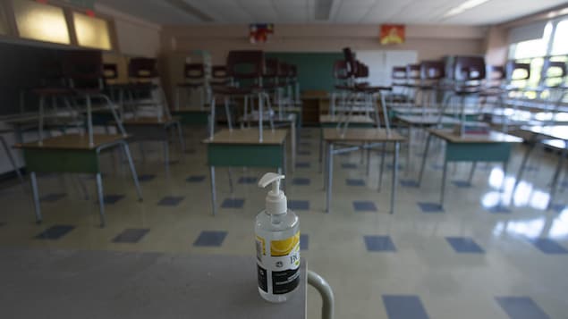 Une bouteille de gel désinfectant dans une salle de classe.