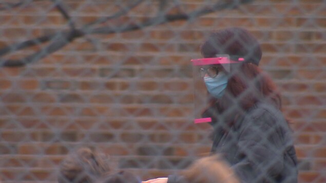 Une enseignante avec ses élèves dans une cour de récréation