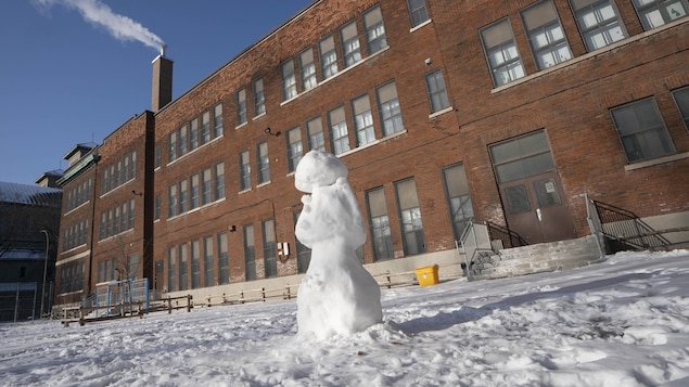 Un bonhomme de neige dans la cour d'une école.