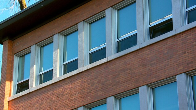 Les fenêtres ouvertes d'une école en briques.