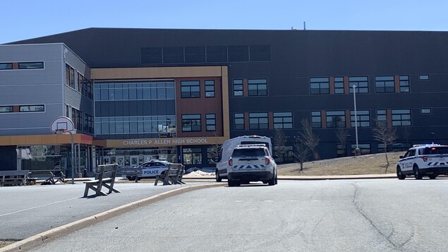 Plusieurs voitures de police sont présentes devant l'entrée de l'école secondaire Charles P. Allen.. 