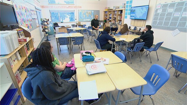 Une classe de secondaire avec six élèves parle à leur enseignant. Une classe de secondaire avec six élèves parle à leur enseignant.