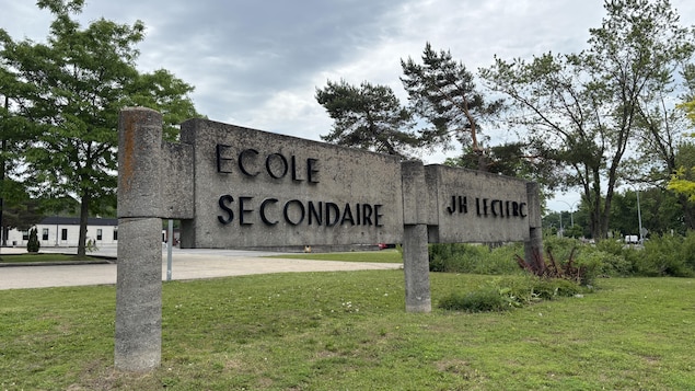 Une grande bannière de béton indique le nom de l'école, devant l'établissement.