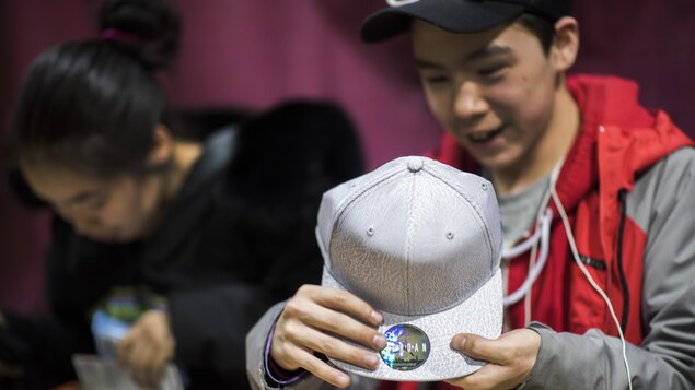 Justin Assevak tenant la casquette offerte par un étudiant d'une école secondaire de Gatineau grâce à l'organisme J'aime les Premiers Peuples.