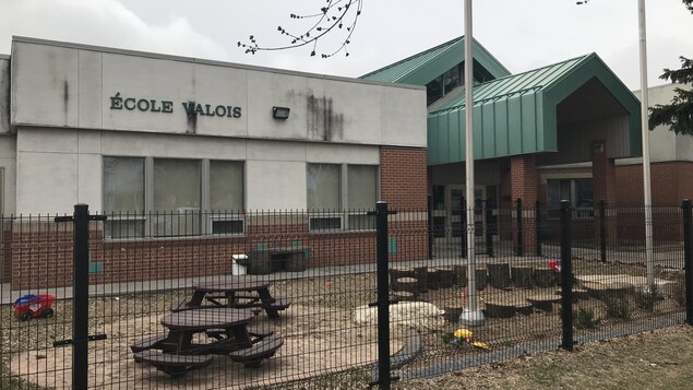 L'entrée et la cour de l'École Valois, entourée d'une clôture robuste.