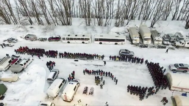 Une vue aérienne permet de voir que des dizaines de personnes participent aux opérations de secours. Une vue aérienne permet de voir que des dizaines de personnes participent aux opérations de secours.