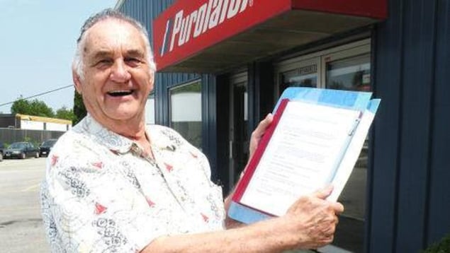 Ed Deibel qui tient un document devant les bureaux de Purolator. Ed Deibel qui tient un document devant les bureaux de Purolator.