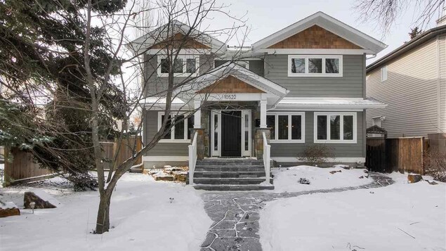 Façade d'une large maison à Edmonton avec un très grand terrain devant la résidence.