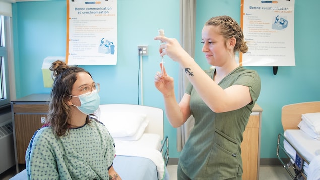 Une étudiante en soins infirmiers prépare une seringue pour une patiente.