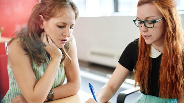 Deux femmes assises à une table. Deux femmes assises à une table.
