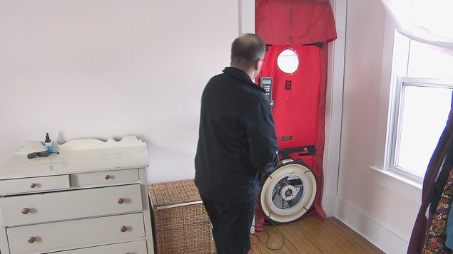 Un évaluateur fait l'examen d'une porte dans une pièce de la maison Un évaluateur fait l'examen d'une porte dans une pièce de la maison