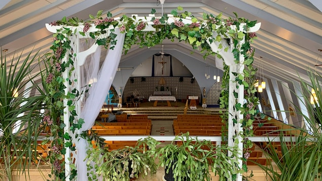 Un décor pour un mariage composé de plantes dans l'église.