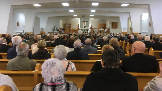Des fidèles assis pour écouter la messe à l'intérieur de l'église. Des fidèles assis pour écouter la messe à l'intérieur de l'église.