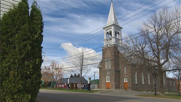Un bâtiment religieux en brique grise se trouve au coeur de la municipalité.