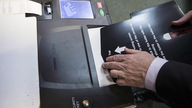 Ontario's Chief Electoral Officer Greg Essensa slides a ballot into a vote tabulator as he demonstrates an electronic voting machine during a media availability in Toronto on Wednesday, May 9 , 2018. THE CANADIAN PRESS/Chris Young