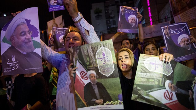 Des partisans du président sortant Hassan Rohani brandissent des affiches électorales. Des partisans du président sortant Hassan Rohani brandissent des affiches électorales.