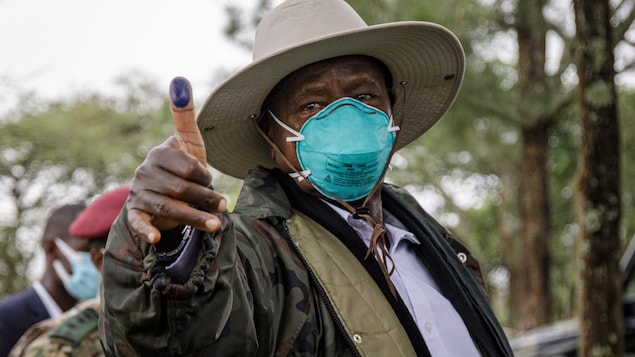 Le président ougandais Yoweri Museveni montre son pouce marqué à l'encre après avoir déposé son bulletin de vote au bureau, le 14 janvier 2021.