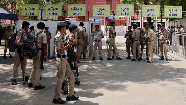 Une vingtaine de policiers indiens, debout devant un centre de comptage.