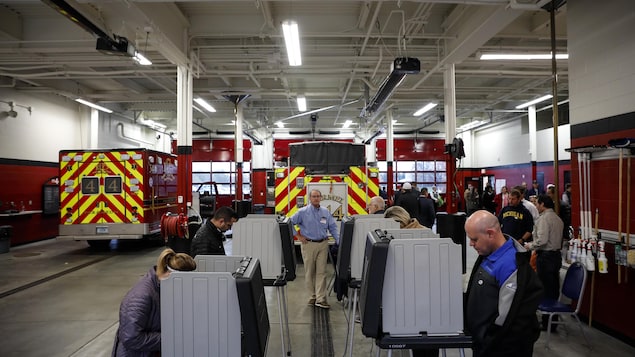 Des électeurs votent dans une caserne de pompiers. Des électeurs votent dans une caserne de pompiers.