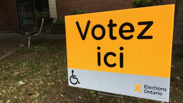 Photo d'une affiche jaune qui dit: Votez ici