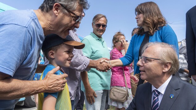 Jean-François Lisée serre la main d'un enfant.