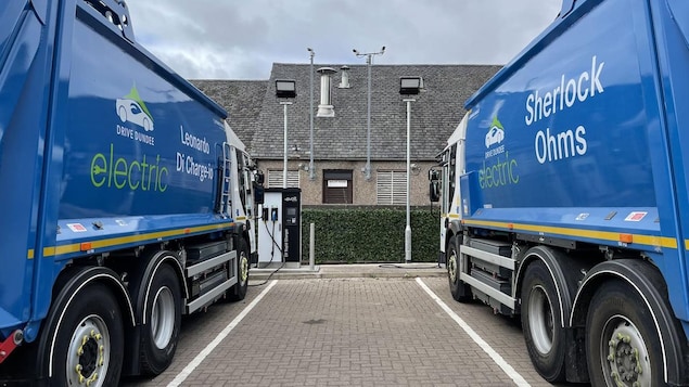 Two electric garbage trucks in a car park in Dundee, Scotland.