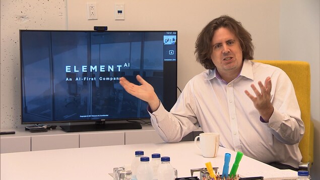 Le cofondateur d'Element AI devant un écran Le cofondateur d'Element AI devant un écran