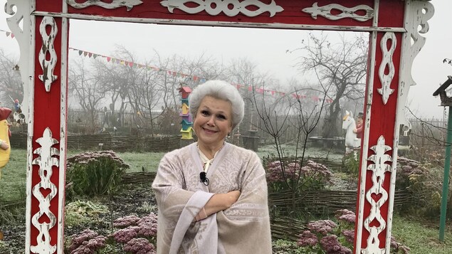 Une dame aux cheveux blancs et chignon est dans son jardin. Une dame aux cheveux blancs et chignon est dans son jardin.