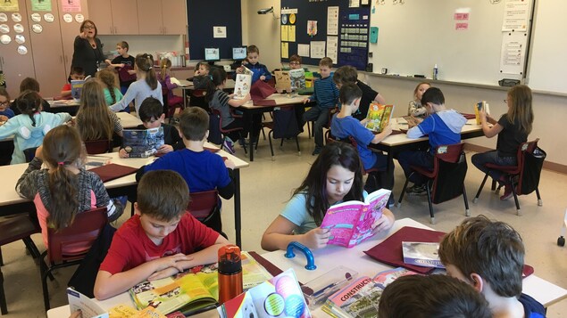Des élèves assis en classe font de la lecture