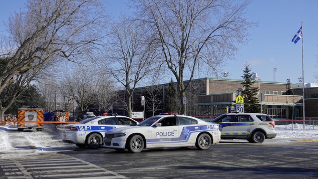 Ambulances et voitures de police devant l'école