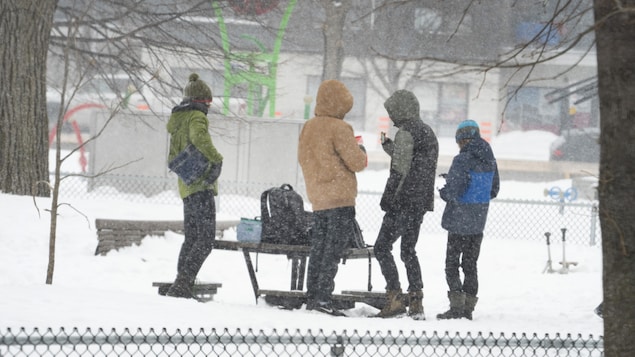 Des adolescents prennent une pause dans un parc enneigé.