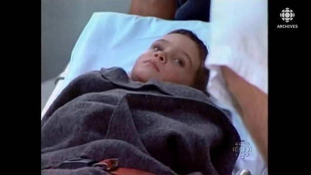 Elian Gonzalez sur une civière, emmitouflé dans une couverture de laine.