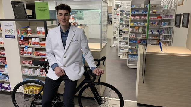 Elliott Doyle appuyé sur un vélo dans la pharmacie où il travaille.