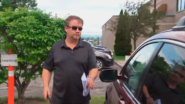 Éloi Bossé se dirige vers sa voiture, un papier à la main.
