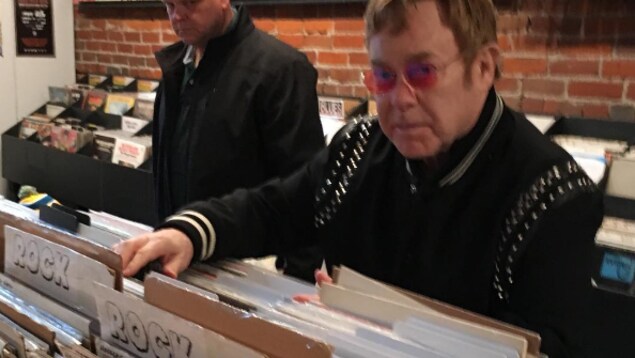 Le chanteur britannique sir Elton John et son garde du corps dans le magasin de disques Beat Street Records au centre-ville de Vancouver le 9 mars 2017
Le chanteur britannique sir Elton John et son garde du corps dans le magasin de disques Beat Street Records au centre-ville de Vancouver le 9 mars 2017