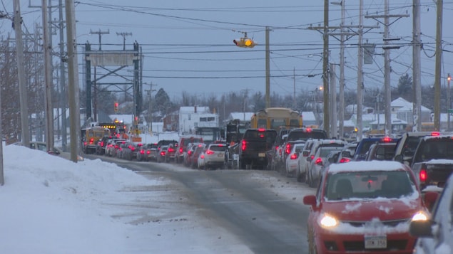 Une file de voitures en attente pour traverser un pont.