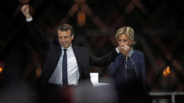Le nouveau président de la France Emmanuel Macron et sa conjointe Brigitte Trogneux accueillant la victoire devant les partisans réunis au Musée du Louvre.