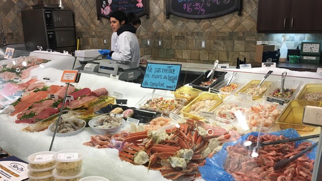 Une employée au Marché de poisson Sherbrooke sert une cliente. Une employée au Marché de poisson Sherbrooke sert une cliente.