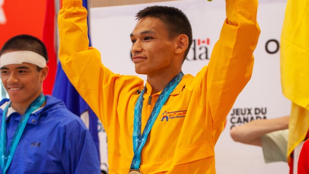 Eekeeluak Avalak avec sa médaille autour du cou, sur le podium, aux Jeux d’été du Canada, le 11 août 2022, dans la région de Niagara