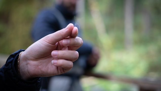 Une main tient un poil entre ces doigts, près de Klemtu, en Colombie-Britannique, en octobre 2023.