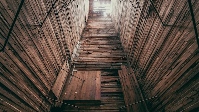 L'intérieur d'un vieux silo en bois, comme un grand puits fait de planches, à Barnsley au Manitoba, début juin 2022.