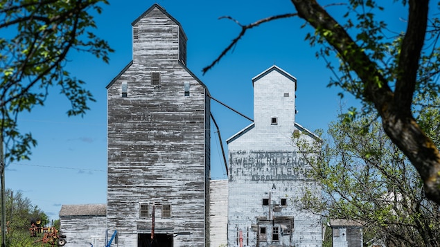 Un vieux silo à grain, avec des machines agricoles, à Isabella au Manitoba, début mai 2022.