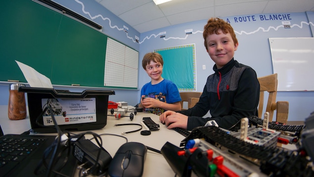 Deux jeunes garçons fabriquent un robot.