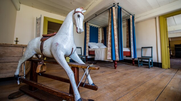 Un cheval de bois et un lit à baldaquin dans une chambre d'enfant datant du 18e siècle.