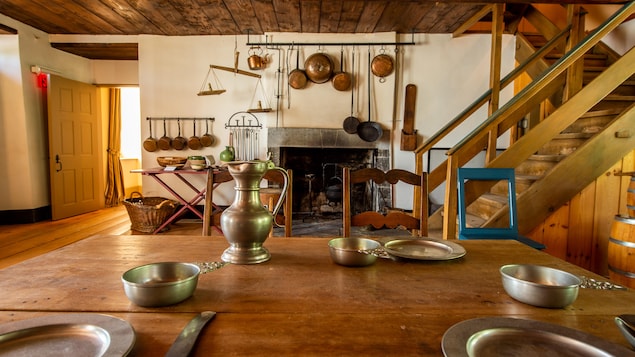Des éléments de cuisine en métal dans une cuisine de bois ancienne datant du 18e siècle.