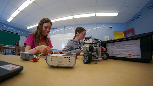 Deux jeunes filles fabriquent un robot.